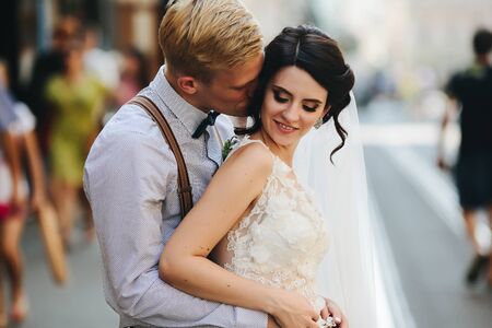 the bride and groom posing for the camera on the streets of the old townの写真素材