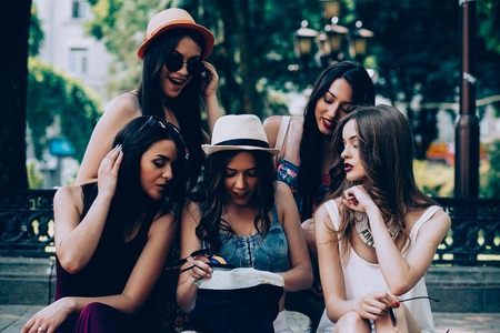five beautiful young girls consider the bag in the parkの写真素材