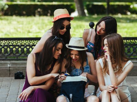 five beautiful young girls consider the bag in the parkの写真素材