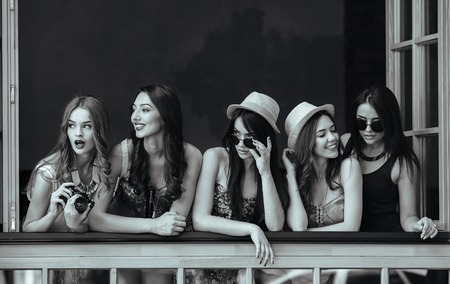 five beautiful young girls look out from the windowの写真素材