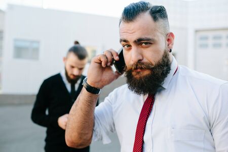 Two bearded businessman working on the street, closeの写真素材