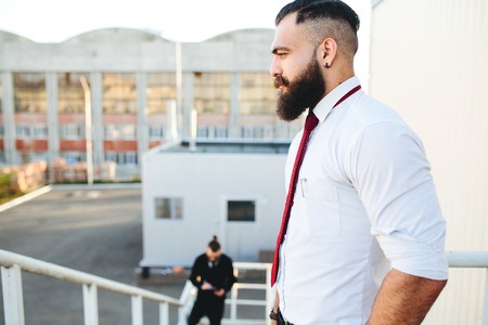 Two bearded businessman looking at something in the streetの写真素材