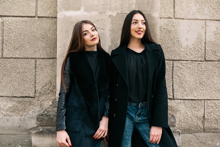 Two young adult women posing on a city streetの写真素材