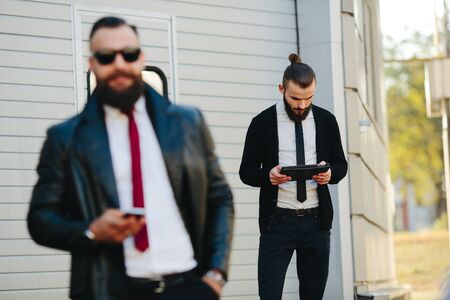 Two bearded businessmen working on the streetの写真素材
