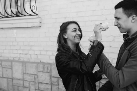 handsome guy and beautiful girl playing with ice cream on background wallの写真素材