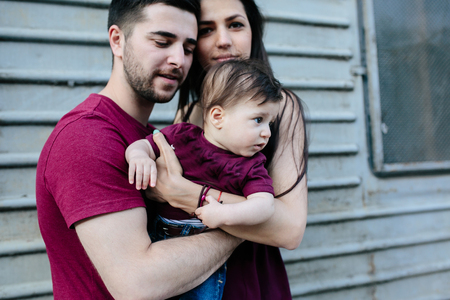 young beautiful family with child posing on the building backgroundの写真素材