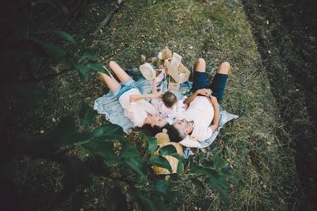 Happy family on the lawn in the park. Photo from treeの写真素材