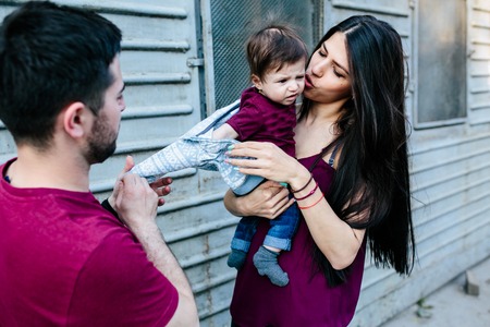 young beautiful family with child posing on the building backgroundの写真素材