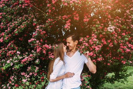 Young happy couple in love outdoors. loving man and woman on a walk in a spring blooming parkの写真素材