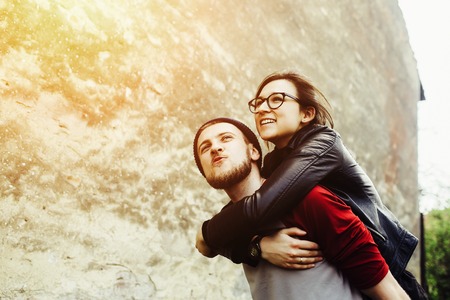 man carries his girlfriend on his back