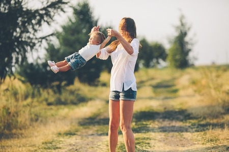 mother and daughter walk together on a rural roadの写真素材