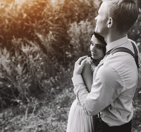 groom gently embracing his bride in the forestの写真素材