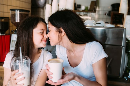 mother daughter drink espresso in the cafeteriaの写真素材