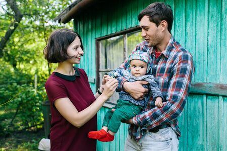Young family with child posing on the background of an abandoned building