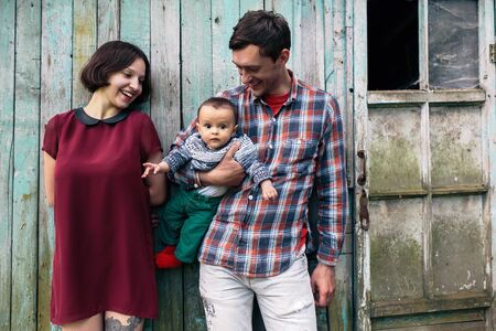 Young family with child posing on the background of an abandoned buildingの写真素材