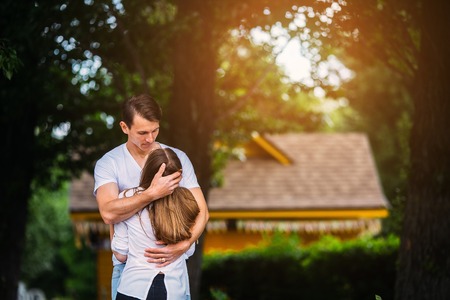 young man gently hugs the girl in the parkの写真素材