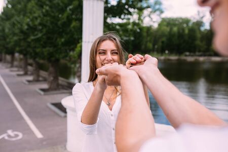 man and woman having fun on a bridge in the parkの写真素材