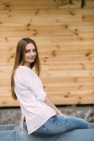 young beautiful woman posing against a background of a wooden wallの写真素材