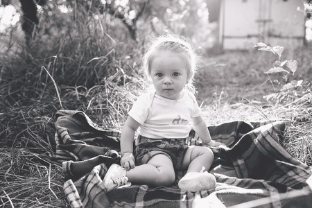 little girl sitting alone on the lawnの写真素材