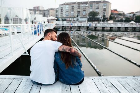 beautiful couple posing on a wooden pier at lakeの写真素材