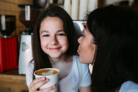 mother daughter drink espresso in the cafeteriaの写真素材