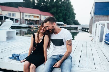 beautiful couple posing on a wooden pier at lakeの写真素材