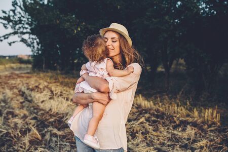 Happy mother and daughter laughing together outdoorsの写真素材