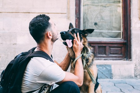 man and dog on the sidewalk posing on camera