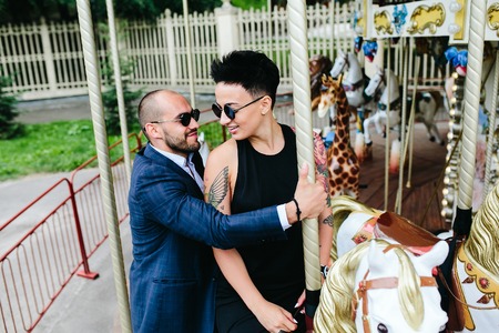 adult man and woman on merry go round carouselの写真素材
