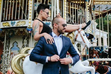 adult man and woman on merry go round carouselの写真素材