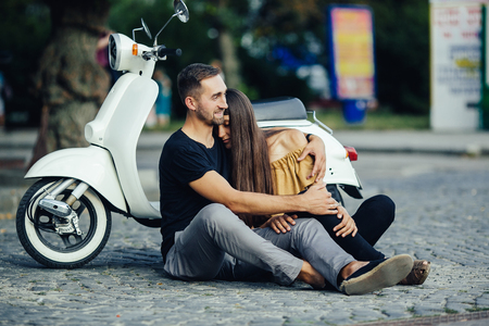 Cute couple with their scooter on a sunny day in the cityの写真素材