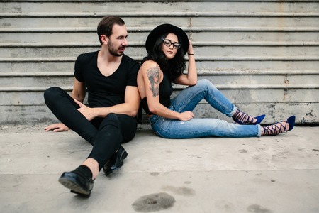 man and woman posing for the camera on a background gray wallの写真素材