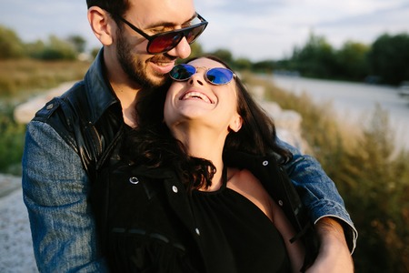 Beautiful young couple in embrace each other near the riverの写真素材