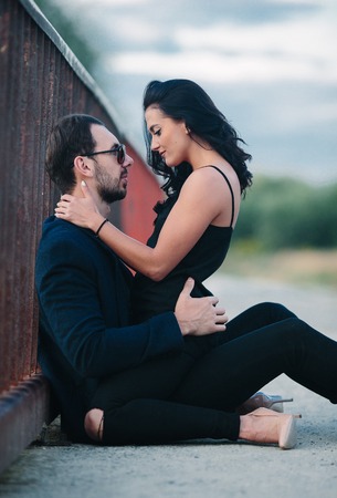 girl sits on a guy and looking at himの写真素材