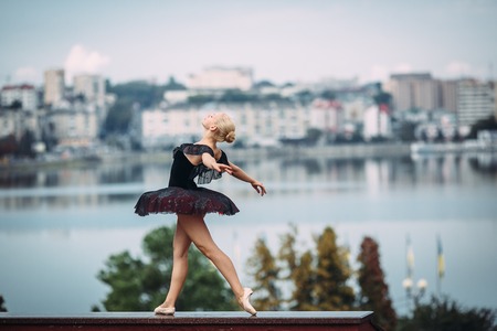 ballerina posing on a background of the lake at the cameraの写真素材
