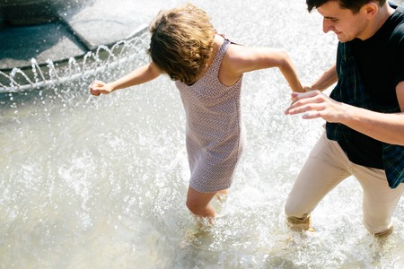 beautiful young couple at the fountain in the parkの写真素材