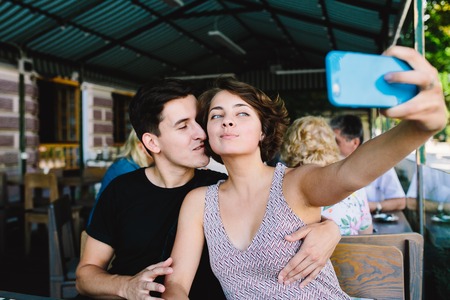 guy and the girl sitting in a cafe outsideの写真素材