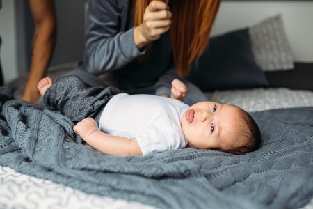 Portrait of a mother with her baby in bedroom at homeの写真素材