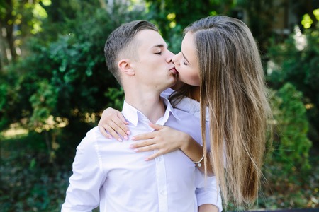 Young man carries his girlfriend on his back in the parkの写真素材