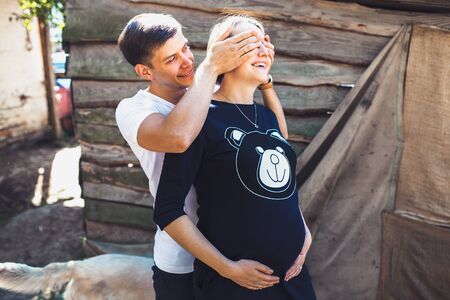 pregnant woman and her husband posing in the countryside at the cameraの写真素材
