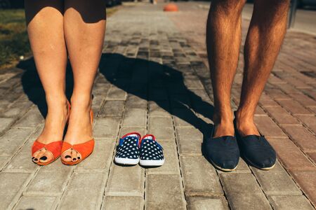 Stylish couple. Closeup of female and male feet in casual shoes on street background.の写真素材