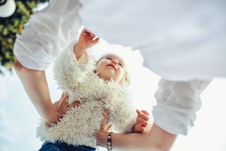 Mother and little daughter playing together in a parkの写真素材
