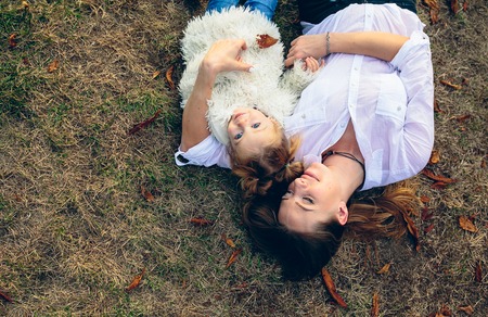 Mother and little daughter playing together in a parkの写真素材