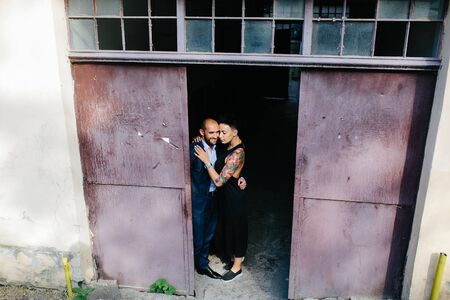 man and woman hugging in the doorway of an abandoned buildingの写真素材