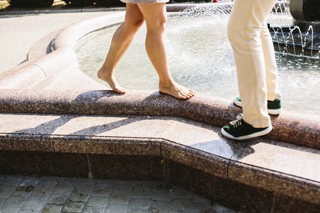 beautiful young couple at the fountain in the parkの写真素材