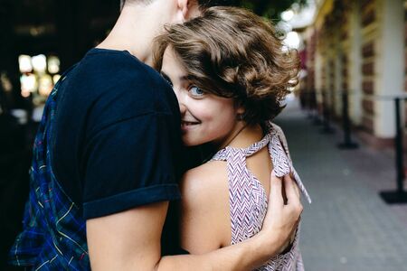 Portrait of a happy couple hugging in the street with the woman face in foregroundの写真素材