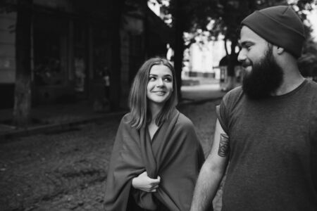 A loving couple walking in the city. A bearded man. Girl with long hair.の写真素材