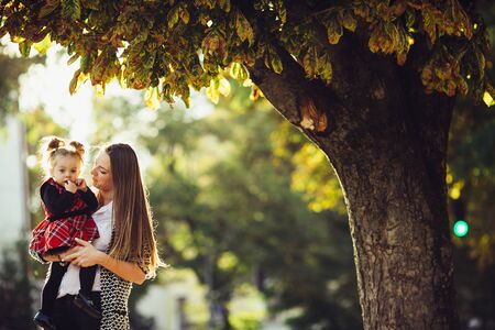 Mother and little daughter playing together in a parkの写真素材