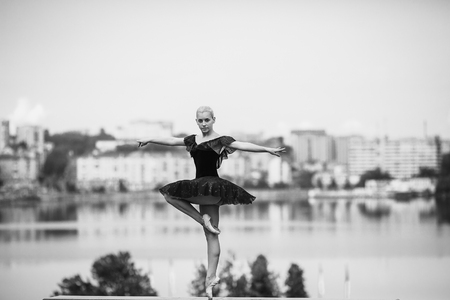 ballerina posing on a background of the lake at the cameraの写真素材