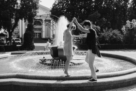 beautiful young couple at the fountain in the parkの写真素材